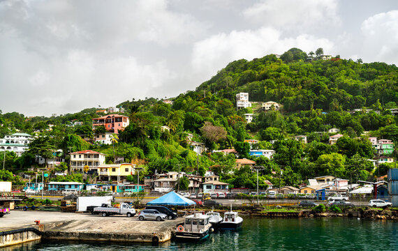 Waterfront pier with boats and colorful houses on a lush tropical hillside in Castries Harbour, Saint Lucia.
