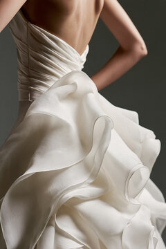 Elegant backless bridal gown featuring luxurious white silk and chiffon fabric with delicate ruffles, soft draping, and intricate couture details