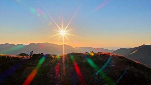Hiker watching a spectacular mountain sunset with a vibrant sunstar lens flare at Col d'Aubisque in French Pyrenees