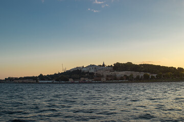 Golden sunset view from the water in Istanbul, with dramatic light, soft clouds and shimmering reflections across the sea. Ideal for travel and cityscape themes. © Dasha Lapshina
