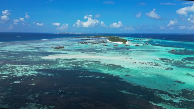 High altitude footage of natural tropical island cluster with deep blue ocean and shallow turquoise water. Concept of nature, geography, ecosystem, and environment.