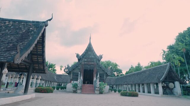 Old Lanna wooden temple hall framed by long cloister galleries