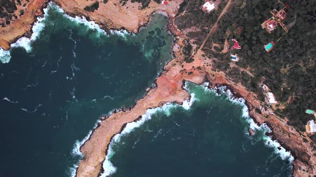 4K drone aerial view of Sa Punta Galera in Ibiza, Spain. Dramatic rocky coastline, crystal-clear Mediterranean waters and distinctive flat rock formations create a spectacular natural landscape.