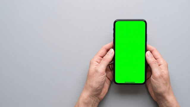 hand holding smartphone with green screen, minimalistic editorial aesthetic on white background