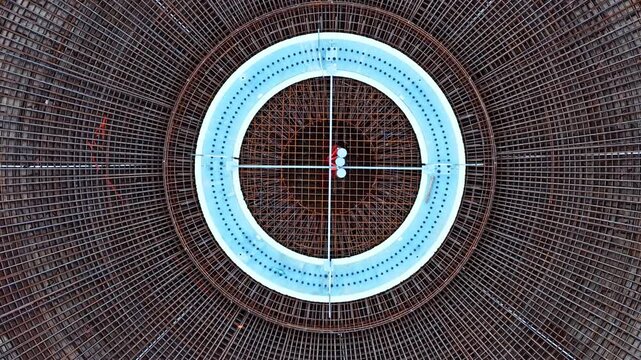 Aerial perspective slowly descending into a circular rebar foundation for a wind turbine