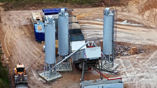 Aerial view of a wheel loader operating at a construction site by a mobile cement plant