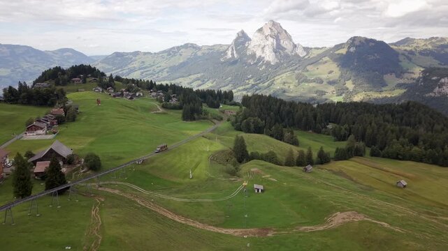 Stoos funicular crossing alpine meadows below Swiss mountain panorama