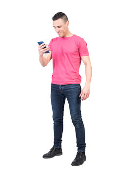 Full body of positive male in casual wear surfing modern cellphone