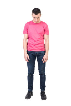 Full body of unpleasant young man in casual wear looking down