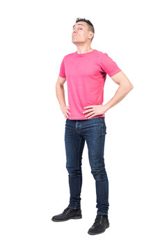 Full body of male guard looking at camera with serious face while standing with hands on waist isolated