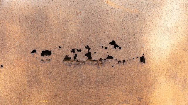Texture old rusty metal featuring dark corrosion spots peeling paint.