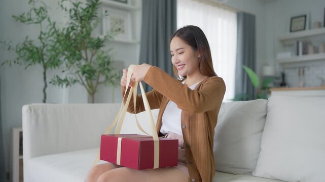 Asian young woman opening a gift box. Happy new year, Thanksgiving