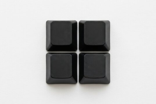 Minimalist Top View of Four Blank Black Computer Keys Arranged in a 2x2 Grid on a Clean White Surface