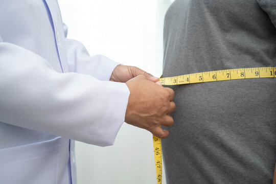 Asian woman with fat belly big size overweight and obesity with measure tape.