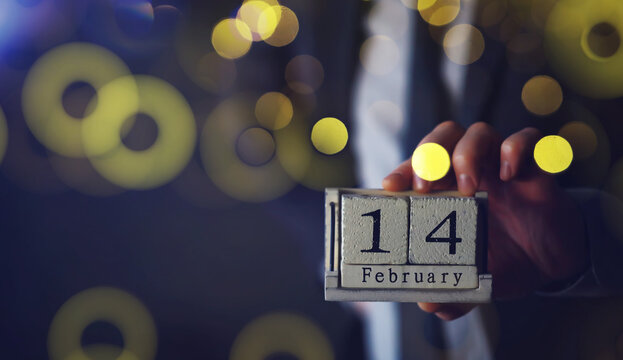 Hand holding wood cubes with 14 February date calendar. concept of Saint Valentine's.
