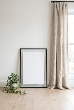 Minimalist scandinavian interior with blank frame and linen curtains