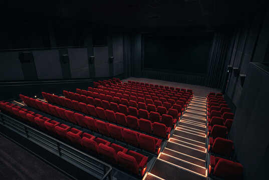 Contemporary movie theater interior with red velvet seats and ambient lighting