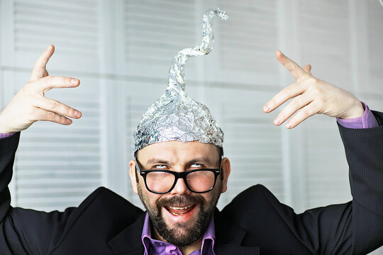 Bearded funny man in a cap of aluminum foil. Concept art phobias.Conspiracy theory. Conspiracy. Insanity.