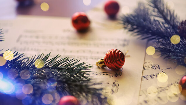 Christmas decorations and fir branch lying on notes sheet