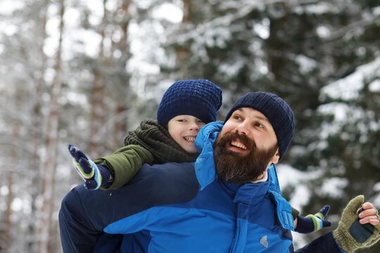 Happy family playing and laughing in winter outdoors in the snow. City park winter day.