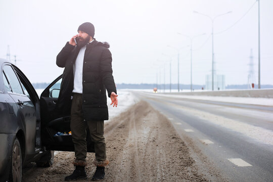 Outdoor portrait of handsome man in coat and scurf. Bearded man in the winter woods.