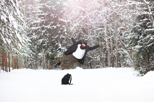 Outdoor portrait of handsome man in coat and scurf. Bearded man in the winter woods.