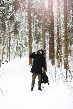 Outdoor portrait of handsome man in coat and scurf. Bearded man in the winter woods.