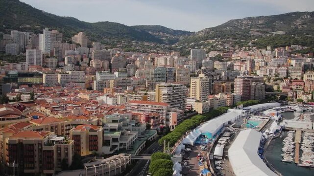 A wide left to right panning shot of the city of Monaco, showing the city's architecture, the harbor, and the Mediterranean sea
