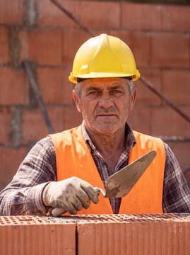 professional worker using masonry trowel and cement mortar during construction