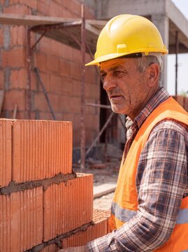 professional worker using masonry trowel and cement mortar during construction