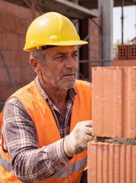 professional worker using masonry trowel and cement mortar during construction