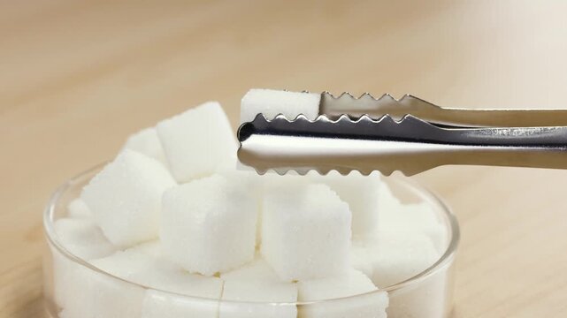 Picking Up White Sugar Cube With Metal Tongs Close Up
