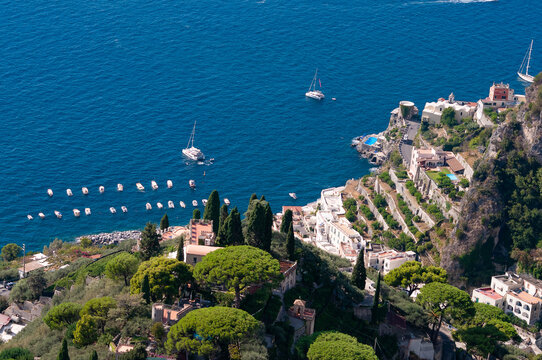 A mediterranean landscape with rocky coastal line of Amalfi coast, Italy, and a boat traveling in the sea along the coast