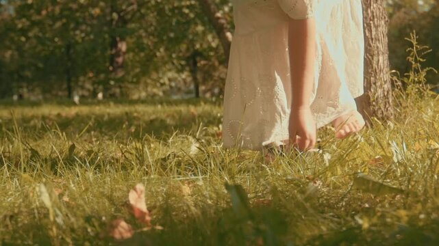 The woman takes off her sandals so she can walk barefoot on the grass. She wants to be one with nature.