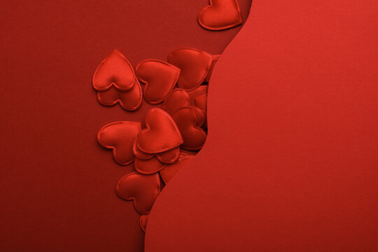 Red hearts on a red wavy layered background. Creative layout. Love concept