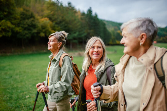 Group of mature female friends enjoying countryside walk.