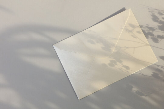 Envelope on gray background with natural sunlight. Business concept. Mockup for design