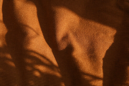 Brown velvet background with shadow from sunlight