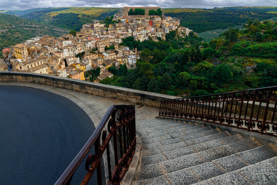 view point scenic overlooking baroque architecture winding streets of an ancient Italian village on top of country side green hill top