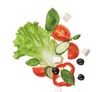 Fresh Greek salad ingredients floating in midair on white background