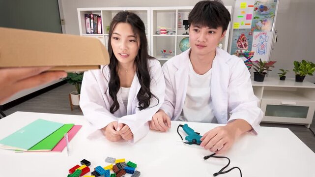 Asian Teenage Students in Science Lab Coats Receiving Craft Materials