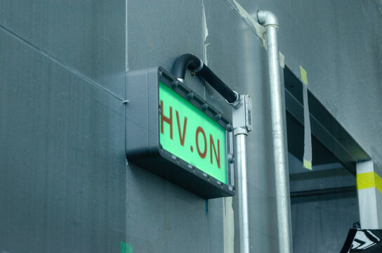 illuminated hv on indicator in industrial setting with metal pipe and neutral mood side view green red gray silver colors educational visual story design resource web.