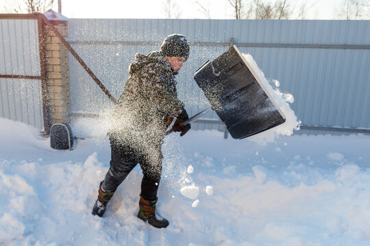 Man shovels snow outdoors in winter
