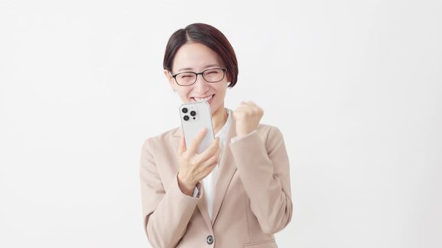 スマートフォンを使う眼鏡をかけたスーツ姿の女性