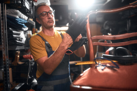 Man working in a workshop for furniture repairing and restoration.