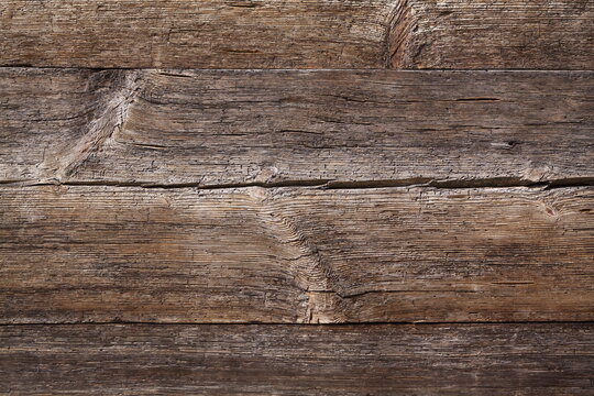 Full frame background texture of aged weathered wooden planks with knots and deep organic grain cracks
