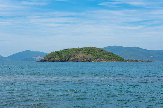 Scenic View of a Serene Island Surrounded by Calm Waters and Lush Greenery Under a Beautiful Blue Sky