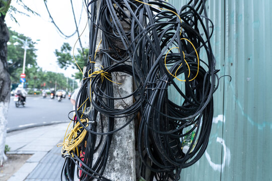 A Chaotic Tangle of Wires and Cables on a City Street, Highlighting Urban Infrastructure and Technical Complexity in Everyday Environments