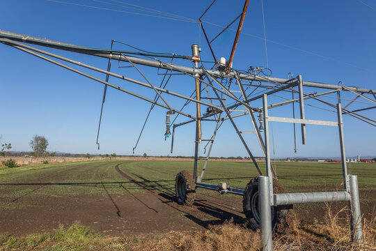 The end piece of a pivot irrigation system showing details of the complexity of a simple machine and the tracks showing its pivoting, circular ability on a crop farm in Queensland, Australia.