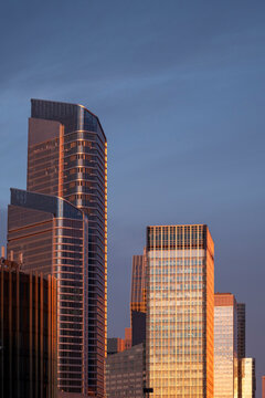 Modern office towers in La Defense business district in Paris, France lit by warm evening sun with glass facades and corporate skyline